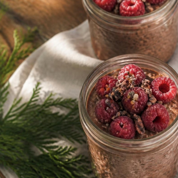 Two jars of chocolate overnight oats topped with raspberries